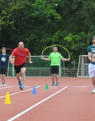 Sportler trainieren auf einem Sportplatz.