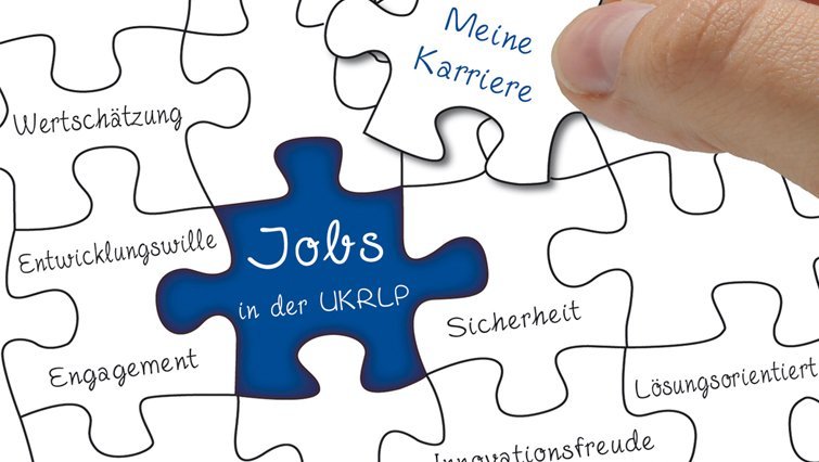 Es ist ein Puzzle zu sehen, auf dem ein Puzzleteil blau gefärbt ist. Auf diesem steht:"Jobs in der UK RLP".